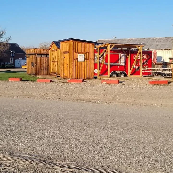 The red Casse-croûte du Village chip wagon trailer with its sign, seating and awning